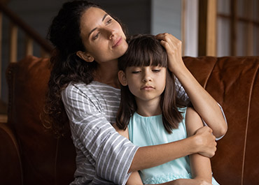 Caring mother hugging and calming upset daughter – child support myths in Texas