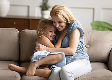 Mother and child hugging on a couch, representing Private Adoptions and a strong petition in Texas family law.